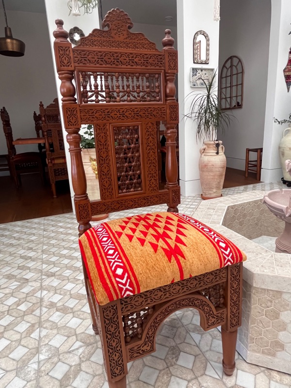 A chair's seat rail, carved with a repeating floral arabesque band.