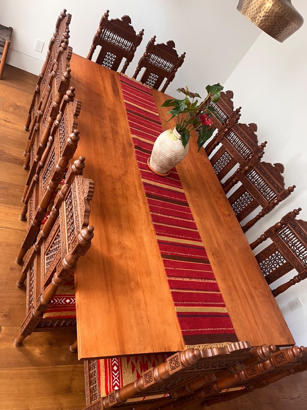 The dining table from above, showing the grain of the solid timber top.